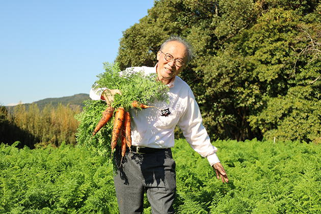 立派に育ったニンジンを笑顔で収穫する菌ちゃん先生